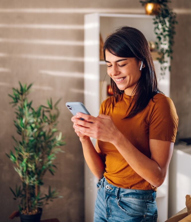Beautiful,Woman,Checking,Social,Media,While,Using,Smartphone,And,Airpods